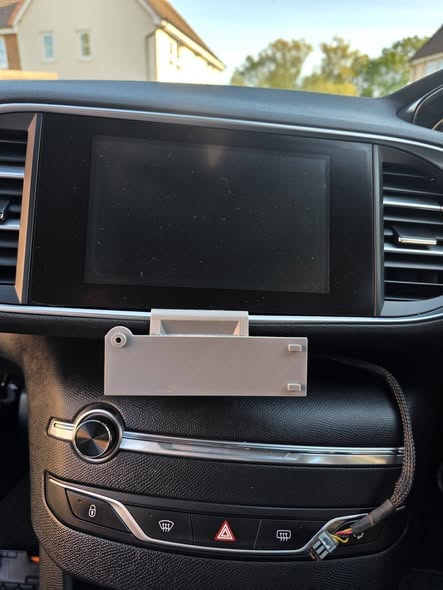 Custom meter bracket mounted below a vehicle infotainment screen